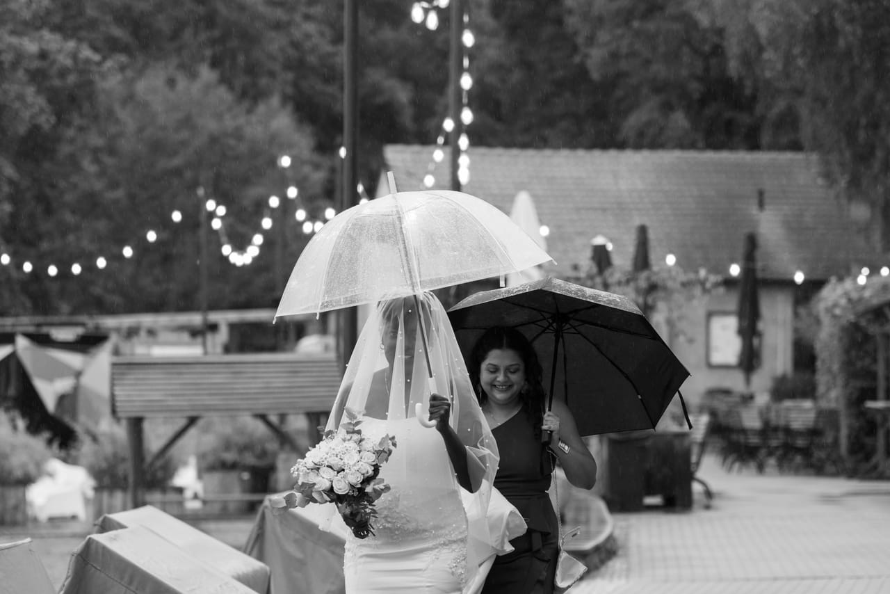 Gäste mit Regenschirmen bei der Hochzeit von Martha und Volker