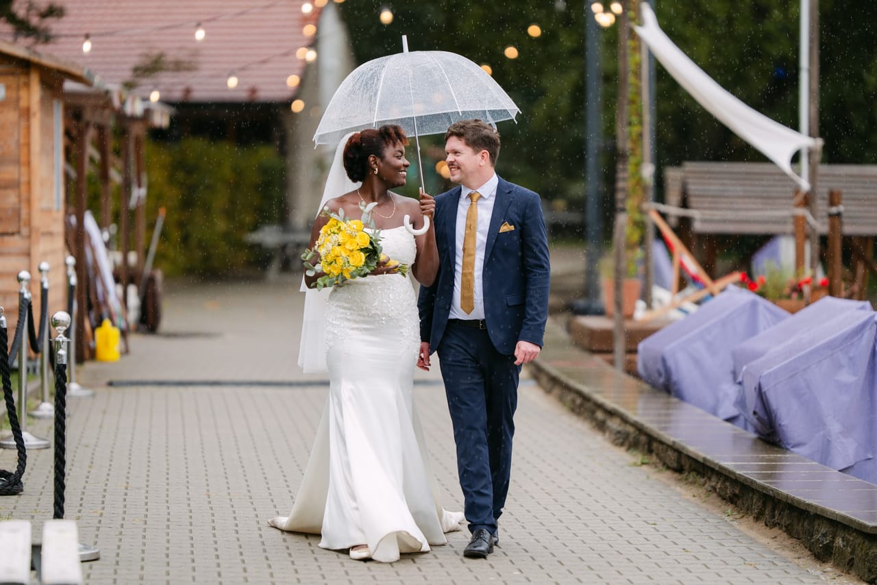 Martha und Volker spazieren im Regen unter Lichterketten